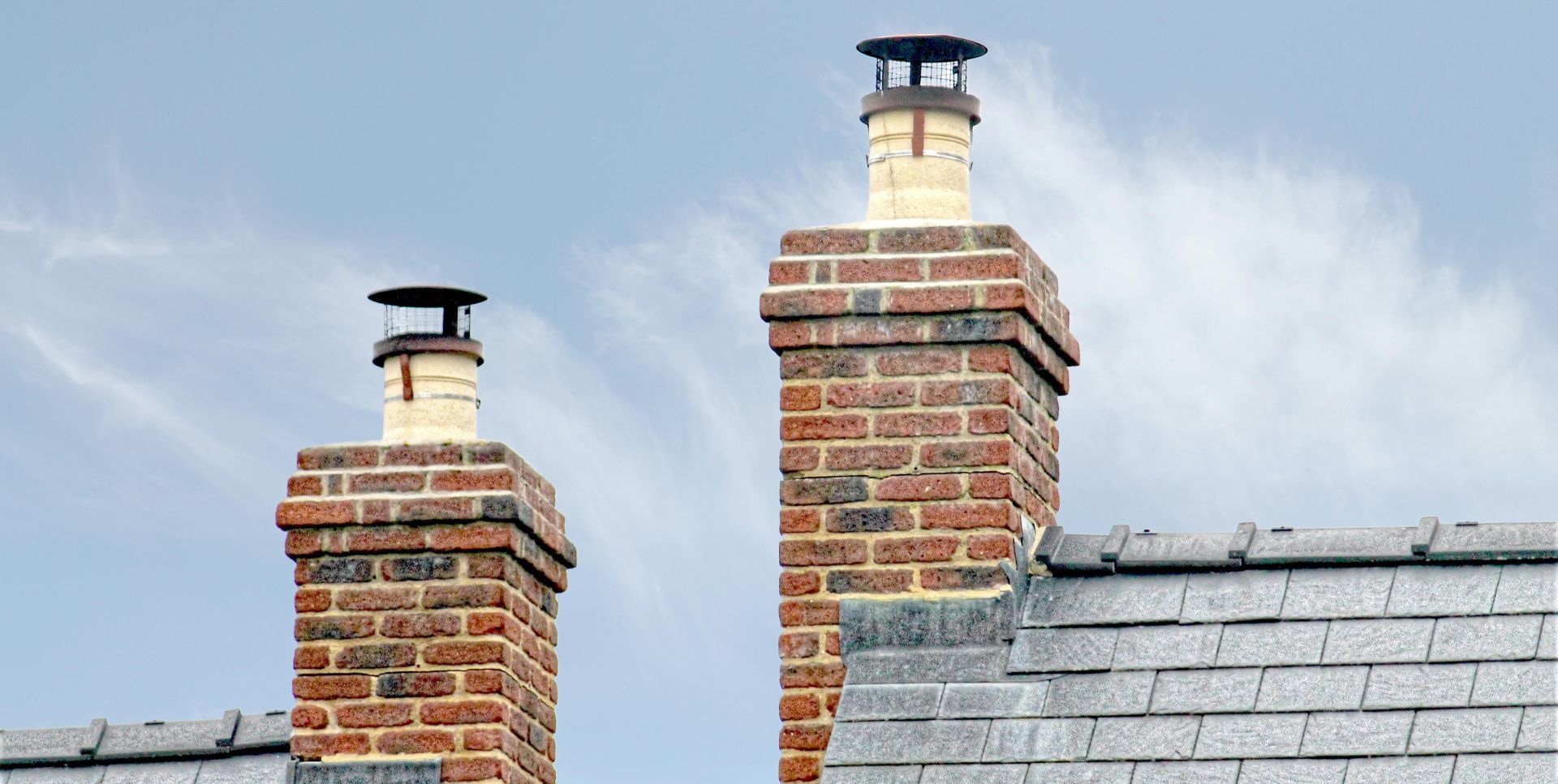 Close-up of traditional brick chimneys on a slate roof, England.